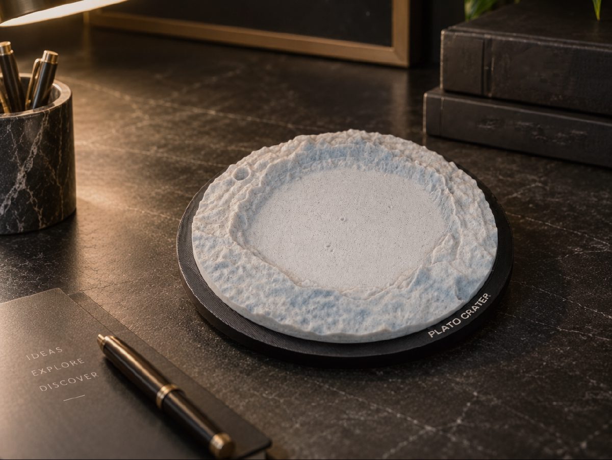 Plato Crater print on a black engraved frame, on a dark marble desk